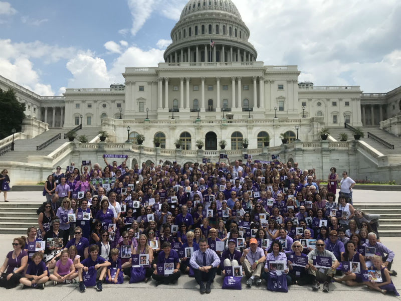 100多名胰腺癌幸存者身穿紫色衣服聚集在国会山前。