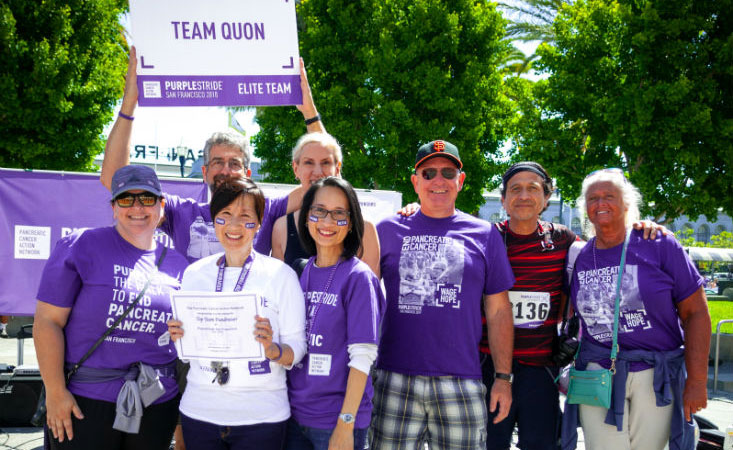 16岁胰腺癌幸存者与5公里步行活动的团队成员微笑，作为顶级筹款人