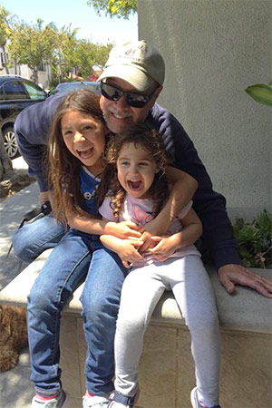 胰腺癌幸存者和父亲与他的两个年轻女儿一起笑
