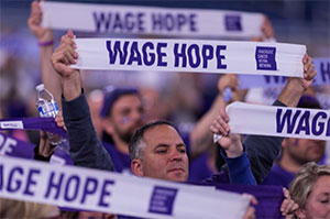 一群胰腺癌的支持者站在一起，举着写有“工资希望”的横幅。