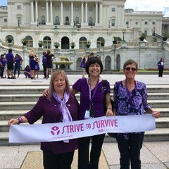 三名胰腺癌幸存者在国会大厦举着“努力生存”的牌子。
