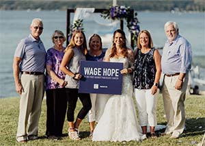 胰腺癌幸存者和志愿者在她的婚礼之日加入新娘与工资希望标志