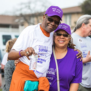 第四阶段的幸存者和他的妻子微笑着走在紫色大道奥斯汀结束胰腺癌