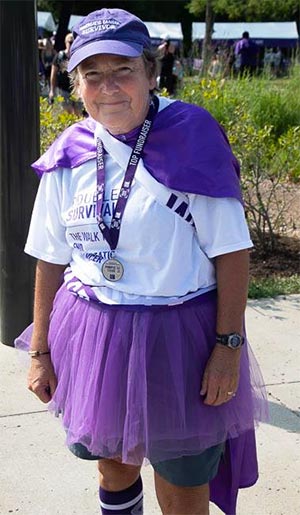 在路易斯维尔癌症行走的潘能志愿者穿着紫色斗篷和最高筹款奖章