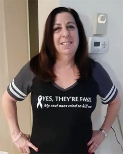 穿着乳腺癌幸存者t恤的女人的全身照片。